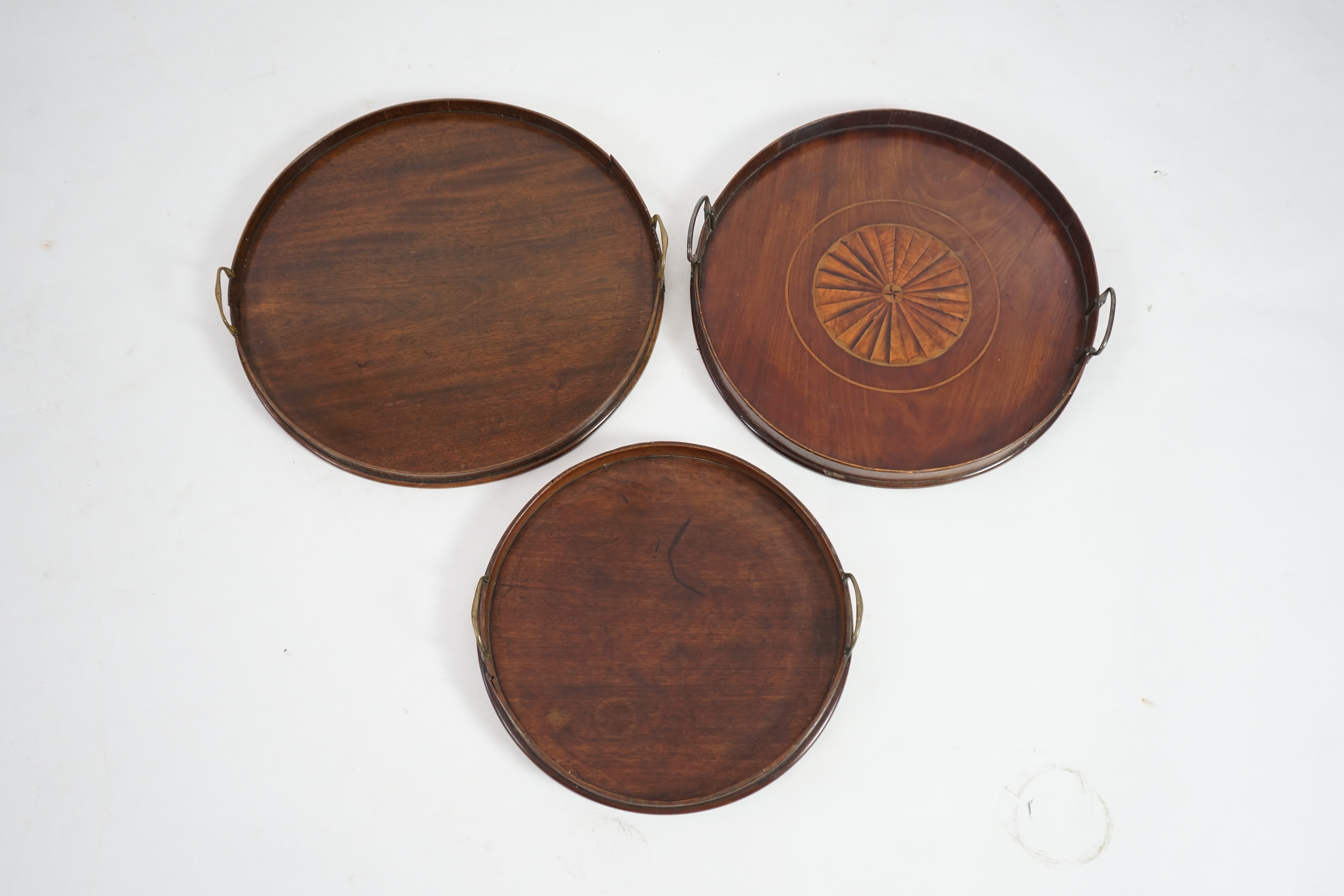 Three George III and later circular mahogany gallery trays